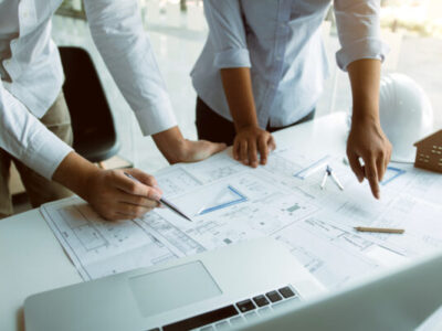 Structural engineering designers are working on the blueprints and analyzing them together.